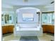Bathroom showcasing a large garden tub surrounded by mirrors, columns, with double vanities and tile flooring at 871 Blairmont Ln, Lake Mary, FL 32746