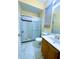 Bathroom featuring a white tiled shower with glass door, vanity with single sink, toilet, and window at 871 Blairmont Ln, Lake Mary, FL 32746