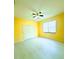 Bedroom features yellow walls and light wood flooring, with a ceiling fan and a large window offering ample natural light at 871 Blairmont Ln, Lake Mary, FL 32746