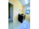 Functional laundry room equipped with modern washer and dryer, tiled floor, and a window for natural light at 871 Blairmont Ln, Lake Mary, FL 32746
