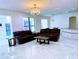 Spacious living room with an elegant chandelier, tile floors, and seamless access to the pool at 871 Blairmont Ln, Lake Mary, FL 32746