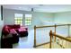 Spacious loft featuring a red sectional sofa and bright windows, offering a comfortable and inviting living space at 871 Blairmont Ln, Lake Mary, FL 32746