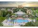 Aerial view of the community featuring a large resort pool, surrounded by palm trees and lush landscaping at 7404 Oconee St, Reunion, FL 34747