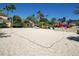 Sandy beach volleyball court with net and seating next to the pool and water park areas at 7404 Oconee St, Reunion, FL 34747