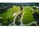 Aerial view of a meticulously maintained golf course with lush green fairways and scenic landscaping at 7404 Oconee St, Reunion, FL 34747