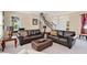 Cozy living room featuring plush leather sofas, soft lighting, and a staircase in the background at 7404 Oconee St, Reunion, FL 34747
