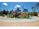 Colorful splash pad with multiple play areas, water features, and seating around the perimeter at 7404 Oconee St, Reunion, FL 34747