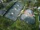 Aerial view of impeccably maintained tennis courts surrounded by lush greenery and beautiful landscaping at 7404 Oconee St, Reunion, FL 34747