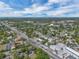 Expansive aerial view of a neighborhood with lush greenery and a clear blue sky with scattered clouds at 2829 Aloma Ave, Winter Park, FL 32792