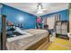 Blue bedroom with a ceiling fan, yellow rug, and a computer desk at 2829 Aloma Ave, Winter Park, FL 32792