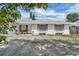 Cozy one-story house with a white exterior, blue trim, brick accents, and a quaint front patio area at 2829 Aloma Ave, Winter Park, FL 32792