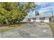 Charming single-story home with a white exterior, large driveway, mature landscaping, and a welcoming entrance at 2829 Aloma Ave, Winter Park, FL 32792