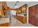 Well lit kitchen, with wood cabinets, black appliances, a neutral countertop, and retro flooring at 2829 Aloma Ave, Winter Park, FL 32792