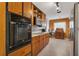 Traditional-style kitchen with wood cabinets, black appliances, and a retro aesthetic at 2829 Aloma Ave, Winter Park, FL 32792