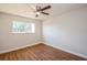 Neutral bedroom with hardwood floors, bright window, and ceiling fan at 1000 Lake Of The Woods Blvd # 103H, Casselberry, FL 32730