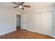 Neutral bedroom with hardwood floors, ceiling fan, closet and access to another room at 1000 Lake Of The Woods Blvd # 103H, Casselberry, FL 32730