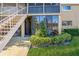 Exterior of the home featuring a ground floor entrance with a stairwell and lush landscaping at 1000 Lake Of The Woods Blvd # 103H, Casselberry, FL 32730