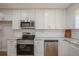 Bright kitchen features stainless appliances, granite countertops, and white cabinets for modern living at 1000 Lake Of The Woods Blvd # 103H, Casselberry, FL 32730