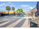 Community pool with lounge chairs, tables, and palm trees providing a relaxing atmosphere for residents at 1000 Lake Of The Woods Blvd # 103H, Casselberry, FL 32730