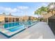 Community pool area featuring lounge chairs, a covered building, and lush trees, providing a refreshing retreat at 1000 Lake Of The Woods Blvd # 103H, Casselberry, FL 32730