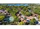 Aerial view of a community with tennis courts, mature trees, and a lake in the background at 1092 E Michigan St # 1, Orlando, FL 32806