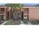 An exterior view showing the condo complex, stairways, mature trees, and well-kept grounds at 1092 E Michigan St # 1, Orlando, FL 32806