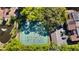 Aerial view shows tennis courts nestled among trees in a vibrant community at 1092 E Michigan St # 1, Orlando, FL 32806