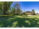 Large backyard featuring a green lawn, trees, landscaping, and the back of a home at 115 Ellington Pl, Oviedo, FL 32765
