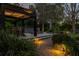Backyard patio with inviting pergola and fire pit with walkway lighting and mature landscaping at 115 Ellington Pl, Oviedo, FL 32765