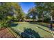 Full basketball court ready for play, nestled among mature trees in a well-maintained yard at 115 Ellington Pl, Oviedo, FL 32765