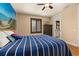 Bright bedroom with a blue striped bedspread, dark wood shuttered windows, and a beach themed mural at 115 Ellington Pl, Oviedo, FL 32765