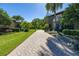 Paver driveway leading to a luxury house with a manicured lawn and landscaping at 115 Ellington Pl, Oviedo, FL 32765