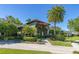 Home exterior view displaying the lush landscaping and blooming flowers with a brick pathway at 115 Ellington Pl, Oviedo, FL 32765