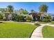 A charming front yard with manicured lawn, palm trees, and brick pathway leading to a home's entrance at 115 Ellington Pl, Oviedo, FL 32765