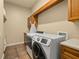 Well-equipped laundry room with a front-load washer and dryer, and wood cabinets for storage at 115 Ellington Pl, Oviedo, FL 32765