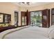 Comfortable main bedroom with wooden shutters that offer views of the pool and backyard at 115 Ellington Pl, Oviedo, FL 32765
