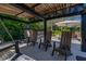Comfortable backyard lounge and fire pit area with chairs and swing seats at 115 Ellington Pl, Oviedo, FL 32765