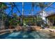 A covered outdoor pool area with a waterfall feature and lush landscaping provides a serene outdoor living space at 115 Ellington Pl, Oviedo, FL 32765