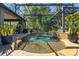 Screened-in pool with waterfalls, accent lighting, pavers, and lush landscaping at 115 Ellington Pl, Oviedo, FL 32765