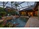 Beautiful screened pool area with water features, lush landscaping, and a relaxing pergola, ideal for outdoor enjoyment at 115 Ellington Pl, Oviedo, FL 32765