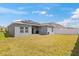 Grassy backyard features a modern home and solar panels at 1174 Tupelo Trl, Haines City, FL 33844