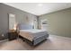 Bedroom features a large bed, neutral paint, carpet flooring, and natural light at 1174 Tupelo Trl, Haines City, FL 33844