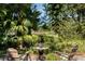 Relaxing backyard patio with a table and chairs set amongst tropical plants at 1188 Brampton Pl, Lake Mary, FL 32746