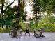 Seating area on the stone patio with a view of the lush greenery and water feature at 1188 Brampton Pl, Lake Mary, FL 32746