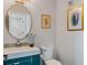 Stylish half bath with a unique mirror, blue vanity and decorative tiling at 1188 Brampton Pl, Lake Mary, FL 32746