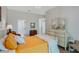 Bright bedroom features a bed with orange patterned linens and a large dresser with round mirror at 1188 Brampton Pl, Lake Mary, FL 32746