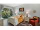 Comfortable bedroom with a large window, hardwood floors, and a cozy armchair at 1188 Brampton Pl, Lake Mary, FL 32746
