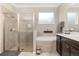 Bathroom featuring a glass enclosed shower, soaking tub, and dark wood cabinets at 12002 Angle Pond Ave, Windermere, FL 34786