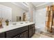 Bathroom with double sink vanity, dark cabinets, and tiled shower/tub combination at 12002 Angle Pond Ave, Windermere, FL 34786