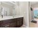 Well-lit bathroom with a dark vanity, a large mirror, and doorways leading to other rooms at 12002 Angle Pond Ave, Windermere, FL 34786